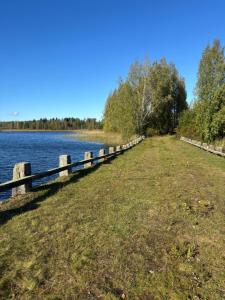 a fence next to a body of water at Villa Sillankorva in Viitasaari +4 photos