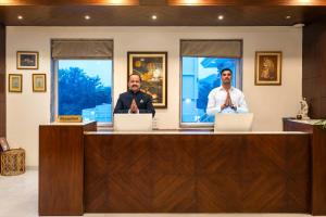 dos hombres sentados en una recepción con ordenadores portátiles en The Colonial - A Lake View Hotel in Udaipur, en Udaipur 15 fotos más