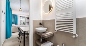 a bathroom with a sink and a mirror and a bed at Residence Cala Vela Tower in Riccione