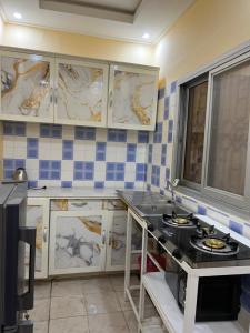 een keuken met blauwe en witte tegels op de muur bij Tataicha Stydio 1 in Ndjamena +14 foto's