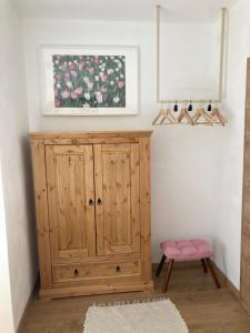 a room with a wooden cabinet and a painting of roses at Haus Werner, Ferienwohnung mit Sommercard in Ramsau am Dachstein +32 photos