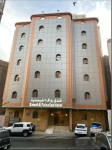 a building with cars parked in front of it at فندق رواف الفيصلية in An Naqāʼ