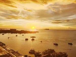 a sunset over a body of water with boats at The Shore LW Premium Suites KK Downtown in Kota Kinabalu