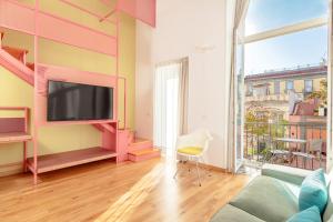 a living room with pink furniture and a large window at Hotel Piazza Bellini & Apartments in Naples
