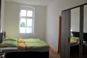 a small room with a bed and a mirror at Alt-Berliner Schwanenhof Ferienwohnung OG links in Lychen +14 photos