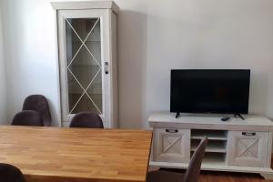 a room with a table and a tv on a cabinet at Alt-Berliner Schwanenhof Ferienwohnung OG links in Lychen