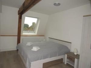 a bedroom with a bed with two towels on it at Alt-Berliner Schwanenhof Ferienwohnung DG rechts in Lychen +15 photos