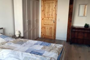 a bedroom with a bed and a wooden door at Alt-Berliner Schwanenhof Ferienwohnung DG rechts in Lychen
