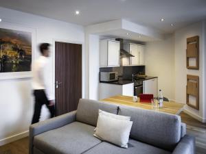 a living room with a couch and a kitchen at Aparthotel Adagio London Brentford in Brentford +57 photos