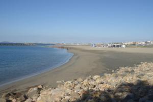 a beach with a bunch of rocks and the water at El Rivet - appartement vue mer avec parking in Sète