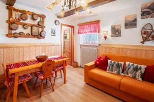 een woonkamer met een bank en een tafel bij Ciasa La Cate in Bellamonte