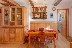 een keuken met een houten tafel en stoelen bij Ciasa La Cate in Bellamonte +15 foto's