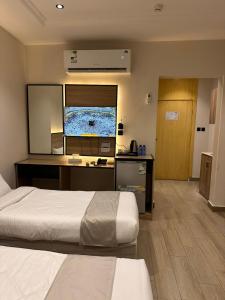um quarto de hotel com uma cama e uma TV de tela plana em فندق رواف الفيصلية em An Naqāʼ
