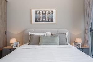 a bedroom with a white bed with two lamps at Urban Chic - Shams Meera in Abu Dhabi