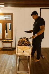 a man is cooking food on a grill at Sapphire Escape - Private Villa in Ambalangoda in Ambalangoda
