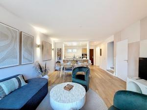 a living room with a couch and a table at L'intemporel YourHostHelper in Deauville