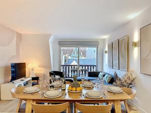 a dining room with a table and chairs and a room at L'intemporel YourHostHelper in Deauville +38 photos