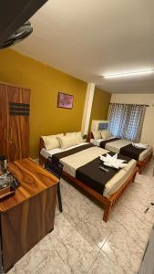 een hotelkamer met twee bedden en een tafel bij Moonlight Residency in Kollam