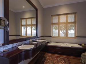 a bathroom with two sinks and a tub and a large mirror at Founders Lodge by Mantis in Paterson