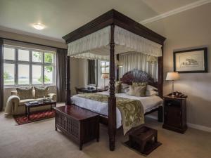 a large bedroom with a canopy bed and a couch at Founders Lodge by Mantis in Paterson