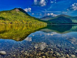 una montagna che riflette nell'acqua di un lago di Mattawamkeag River Cottage a Island Falls