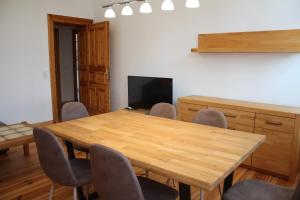 une salle de conférence avec une table et des chaises en bois dans l'établissement Alt-Berliner Schwanenhof Ferienwohnung EG rechts, à Lychen