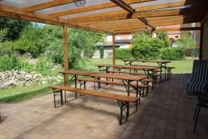 un groupe de tables de pique-nique sous une pergola en bois dans l'établissement Alt-Berliner Schwanenhof Ferienwohnung EG rechts, à Lychen 15 autres photos