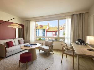 un salon avec un canapé et une table dans l'établissement Le Talaia Hôtel & Spa Biarritz - MGallery Collection, à Biarritz