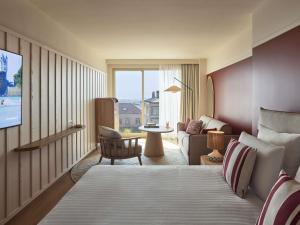 une chambre d'hôtel avec un lit et un salon dans l'établissement Le Talaia Hôtel & Spa Biarritz - MGallery Collection, à Biarritz