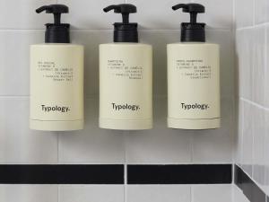 quatre flacons de savon blancs sur une étagère dans une salle de bain dans l'établissement Le Talaia Hôtel & Spa Biarritz - MGallery Collection, à Biarritz 110 autres photos