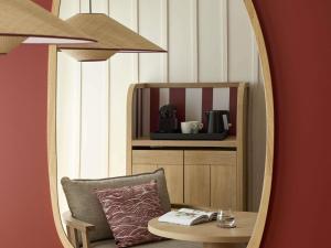 - un miroir dans une chambre avec une chaise et un oreiller dans l'établissement Le Talaia Hôtel & Spa Biarritz - MGallery Collection, à Biarritz