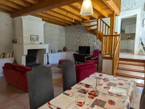 ein Esszimmer mit Tisch und Kamin in der Unterkunft Gîte familial avec piscine chauffée, jardin privé et équipements bébé en pleine propriété viticole. - FR-1-653-18 in Saint-Cybardeaux