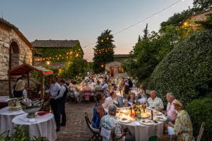 a group of people sitting at tables in a garden at Borgo Vescine in Radda in Chianti +105 photos
