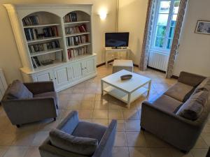 a living room with couches and a table and a tv at Maison de charme avec piscine chauffée et jardin privé, idéale pour familles - FR-1-653-85 in Saint-Cybardeaux