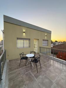 a patio with a table and chairs on a balcony at La posada de Majo 1 in Pergamino