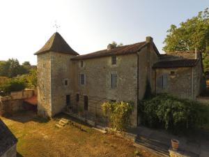 an old stone building with a tower in a yard at Prieuré restauré avec jardin, charme ancien et commodités modernes, près de l’église à Beaulieu - FR-1-653-145 in Beaulieu-sur-Sonnette