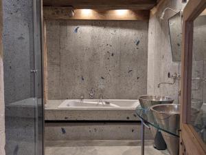 a bathroom with a tub and a glass table at Prieuré restauré avec jardin, charme ancien et commodités modernes, près de l’église à Beaulieu - FR-1-653-145 in Beaulieu-sur-Sonnette +27 photos