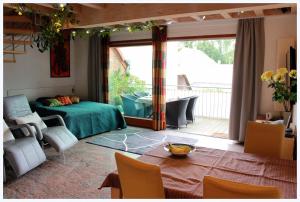 a bedroom with a bed and a table and a balcony at Studio A Am Burgberg in Erlangen