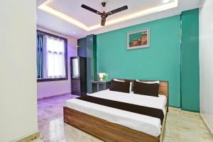 a bedroom with a bed with a blue wall at Super Hotel O Stayo in Patancheru