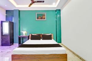a bedroom with a bed with a blue wall at Super Hotel O Stayo in Patancheru +39 photos