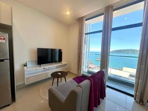 a living room with a tv and a large window at The Shore LW Premium Suites KK Downtown in Kota Kinabalu