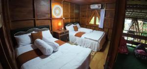 une petite chambre avec deux lits et une table dans l'établissement Villa Ilham Ketembong, à Tetebatu