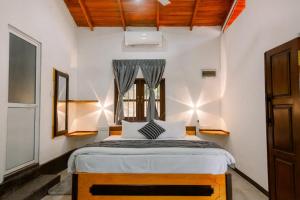 une chambre avec un lit et une fenêtre dans l'établissement Deer House Hiriketiya, à Dikwella