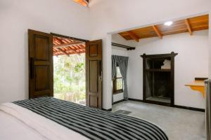 une chambre avec un lit et une porte ouverte dans l'établissement Deer House Hiriketiya, à Dikwella