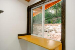 une fenêtre dans une pièce avec une étagère en bois dans l'établissement Deer House Hiriketiya, à Dikwella