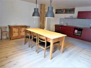 a kitchen with a wooden table and some lights at Biala Biobergün in Bergün