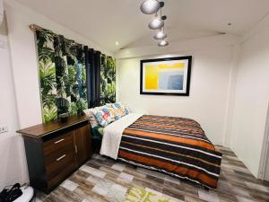 a bedroom with a bed and a dresser in it at Cozy Skyview Villa in Lopez Quezon! in Lopez +37 photos