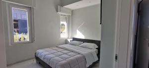 a bedroom with a bed and two windows at Residence Niko in Pratica di Mare