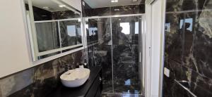 a black tiled bathroom with a sink and a shower at Residence Niko in Pratica di Mare