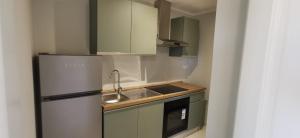 a small kitchen with green cabinets and a refrigerator at Residence Niko in Pratica di Mare
